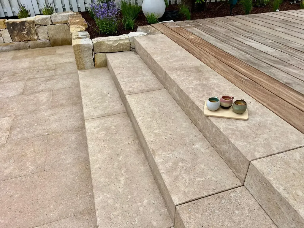 Blockstufen aus Naturstein an einer Holzterrasse