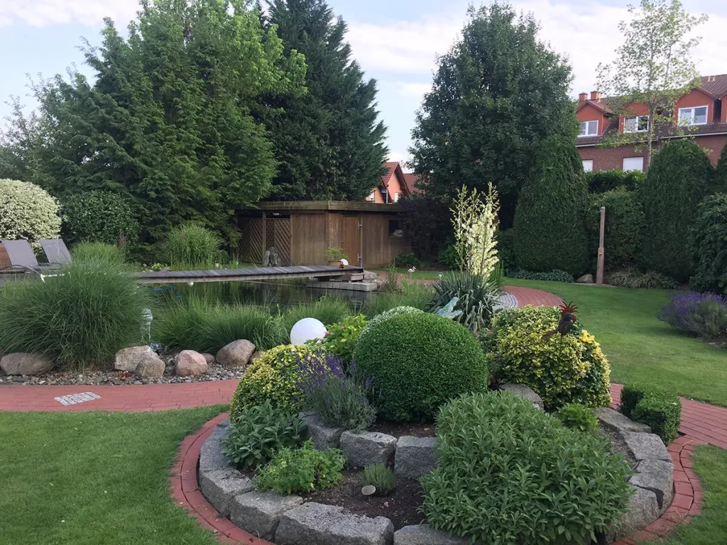 Garten mit geschwungenen Beeten, Sträuchern und Rasen