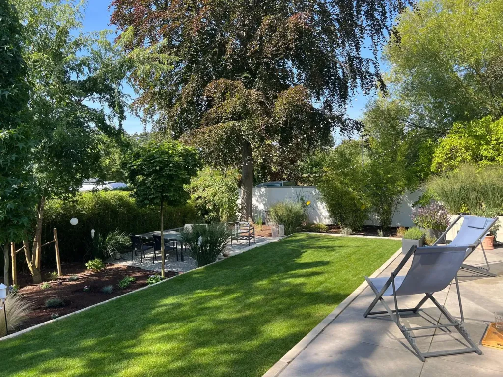 Gartenanlage mit Rasenfläche, Blutbuche und Sitzplatz