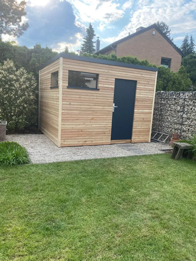 Gartenhaus aus Holz mit Rasenfläche und Gabionenwand