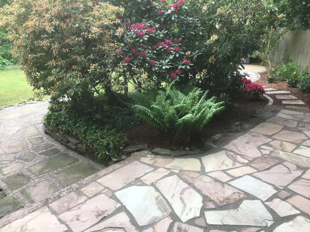 Gartenweg aus Polygonalplatten mit Sträuchern