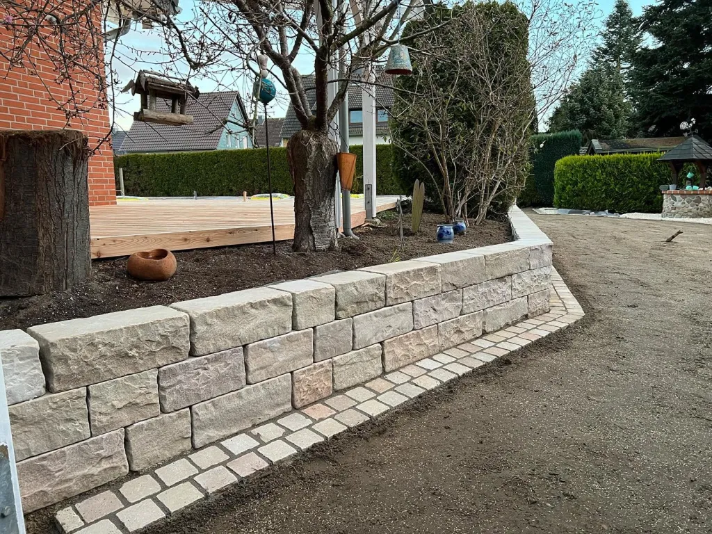 Geschwungene Mauer aus Naturstein im Garten