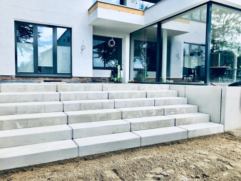 Großzügige Treppe aus hellen Blockstufen an einem modernen Haus