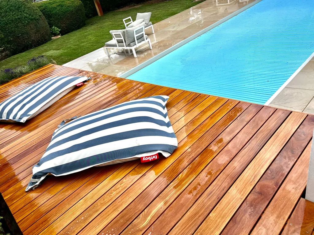 Holzdeck am Pool mit Liegepolstern