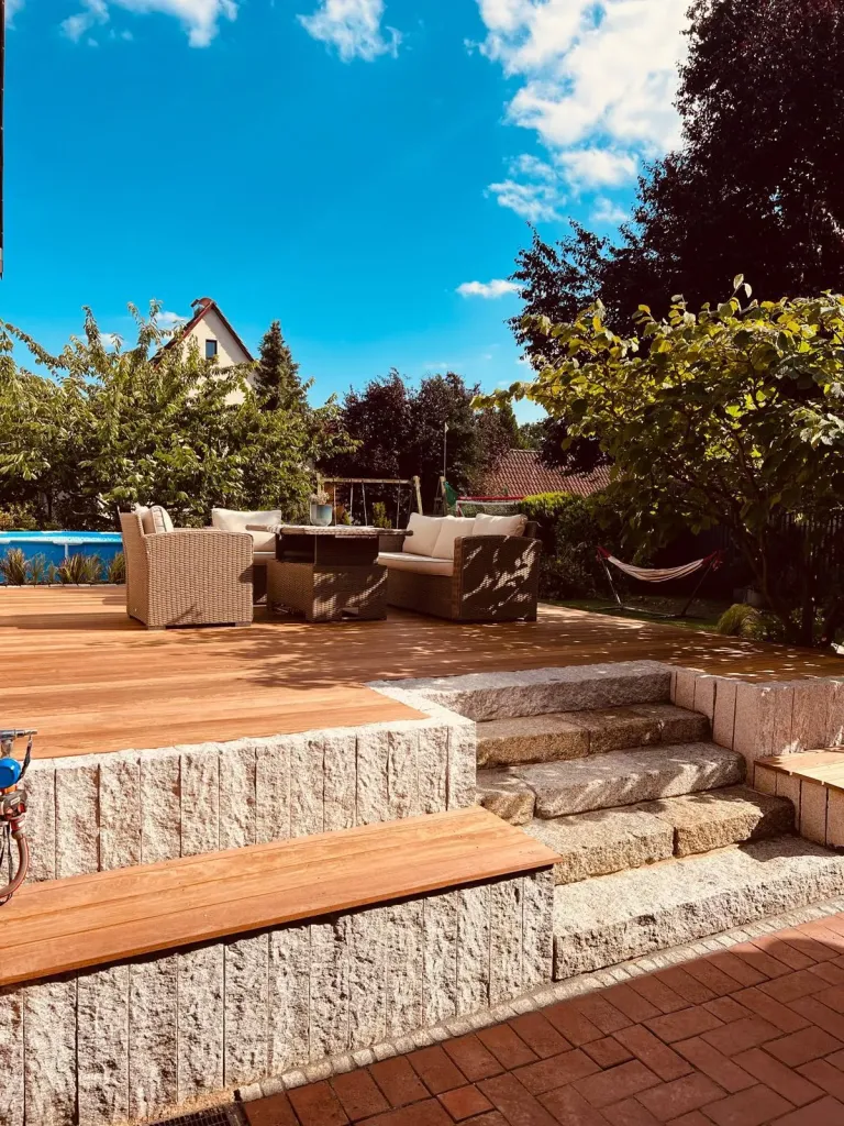 Holzterrasse mit Granit-Blockstufen und Sitzbereich