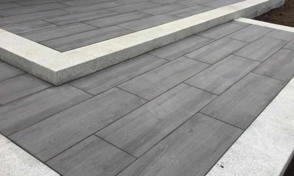 Pflasterfläche aus dunkelgrauen Großformatplatten mit hellem Rand