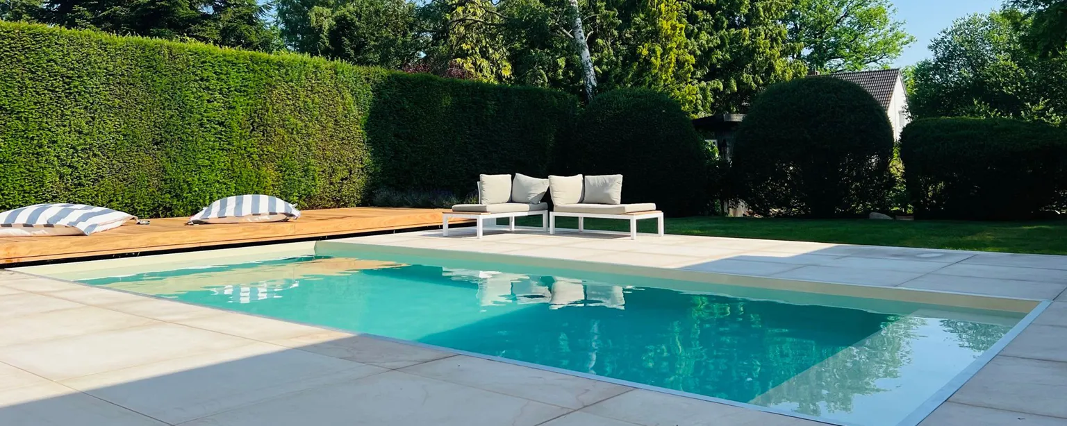 Pool mit großformatigen Terrassenplatten, Loungemöbeln und Hecke – Gartengestaltung Astrein Burgdorf
