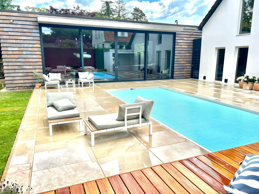 Poolbereich mit Natursteinterrasse und Loungemöbeln