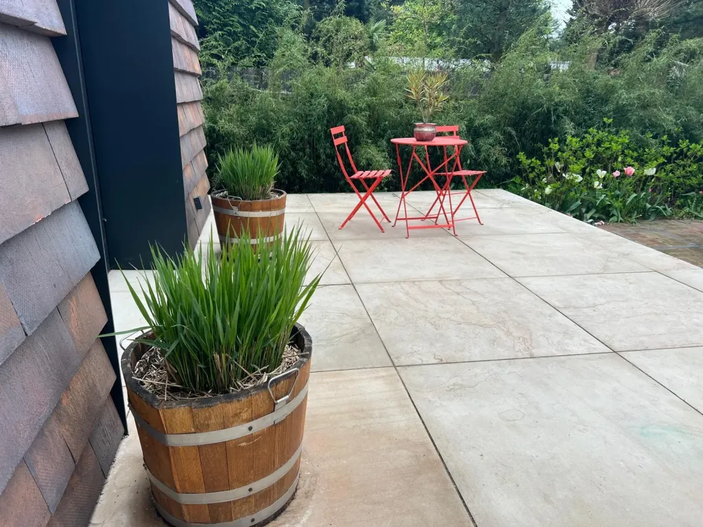 Terrasse aus hellen Großformatplatten mit Kübelpflanzen
