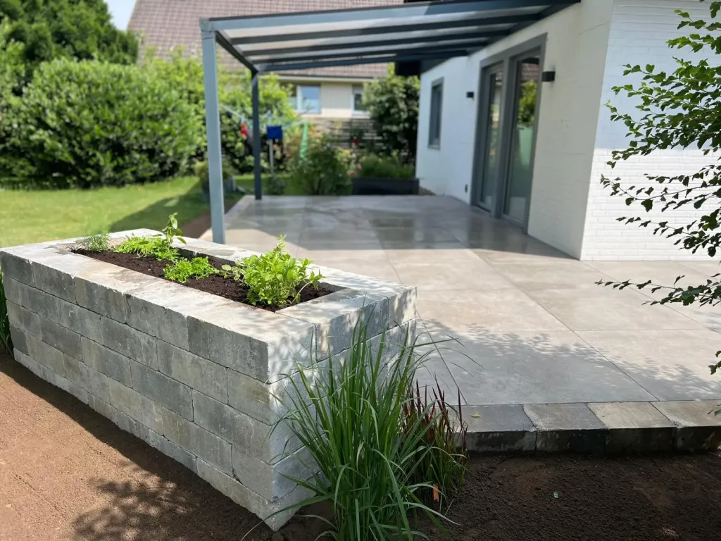 Überdachte Terrasse mit Hochbeet aus Naturstein